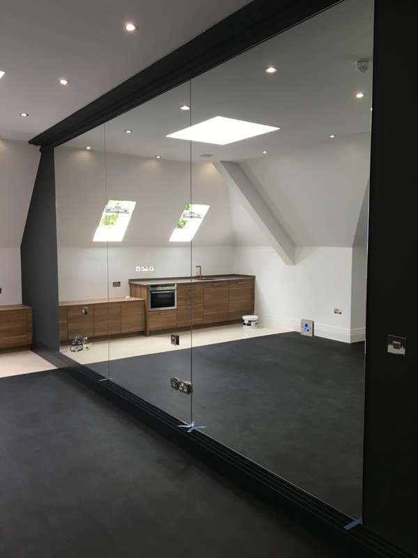 Frameless glass partition in loft conversion by Newbury glaziers
