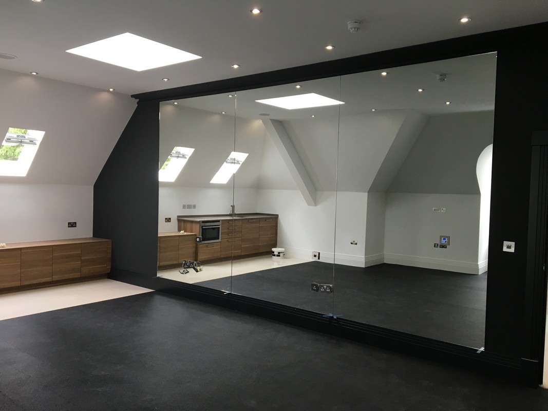 Frameless glass wall dividing loft conversion in Newbury
